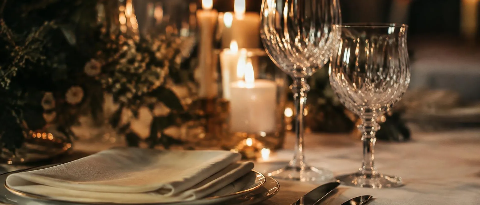 Cutlery and crystal glasses lit by candles.